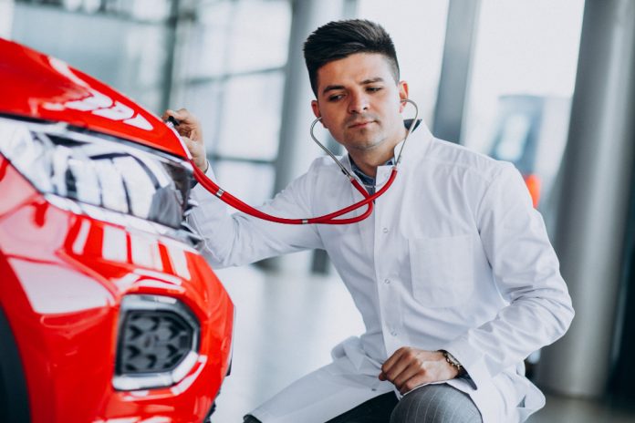 car-technician-with-stethoscope-car-showroom